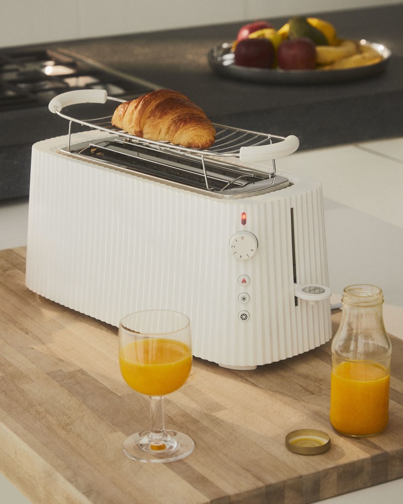 Weißer Alessi Plissé Toaster XXL mit Croissant, Saft und Obst für ein stilvolles Frühstück.