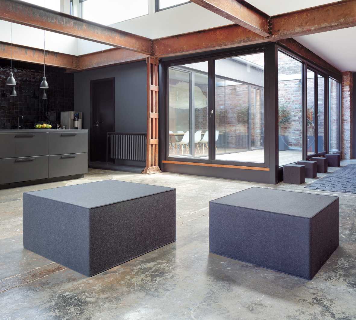 Zwei graue Big Quart Sitzmöbel von Hey Sign in modernem Loft-Ambiente. Filz Sitzhocker für Wohnzimmer.