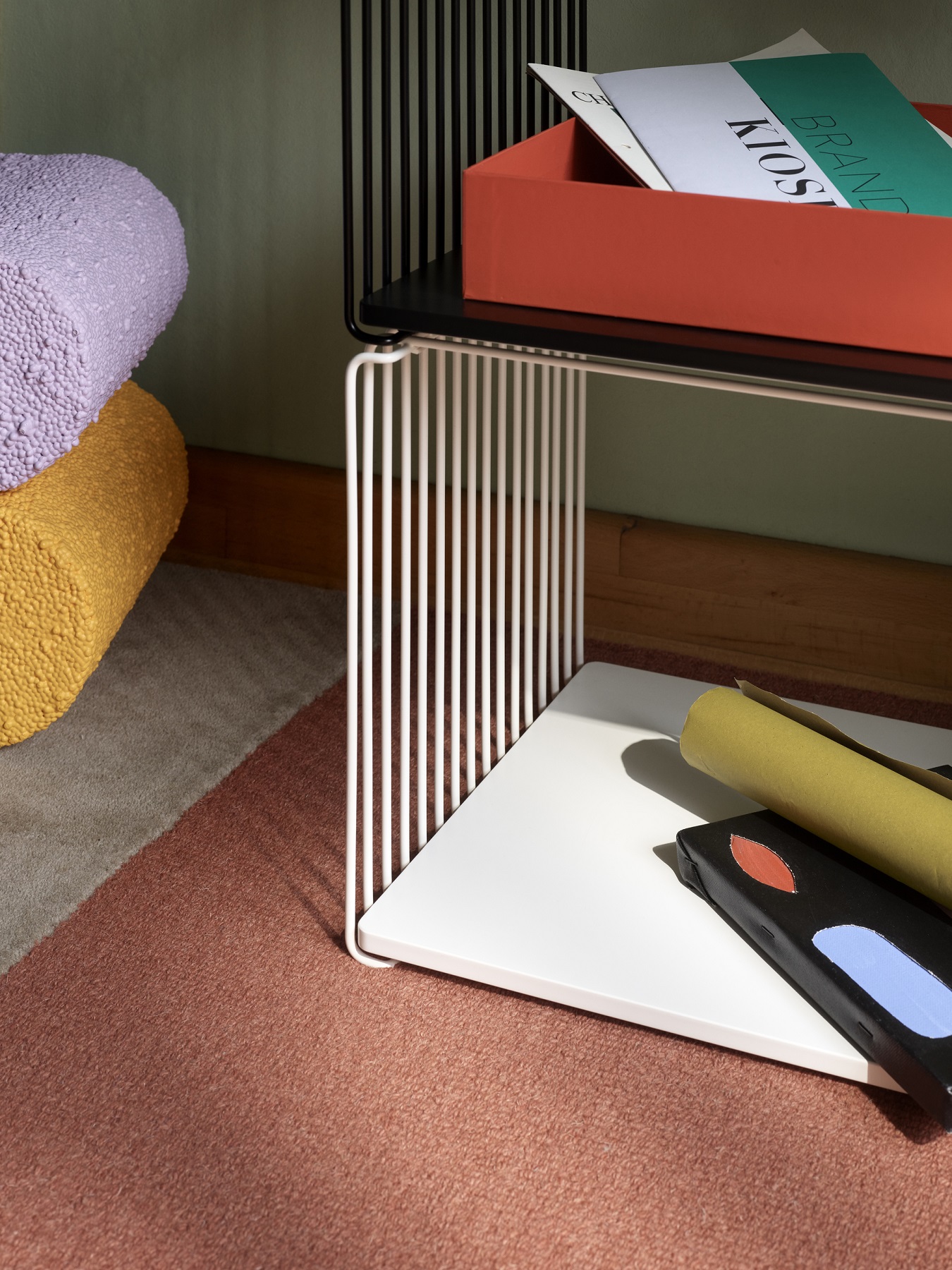 Detailaufnahme des Panton Wire Regalsystems mit Ablageflächen und dekorativen Elementen im Wohnraum.