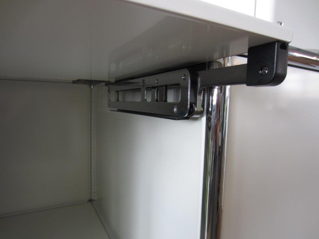 Detailaufnahme: USM Haller Ersatzteil, Einschubtür-Mechanismus, silbernes Metall, schwarze Halterung, zur Reparatur und Instandhaltung.