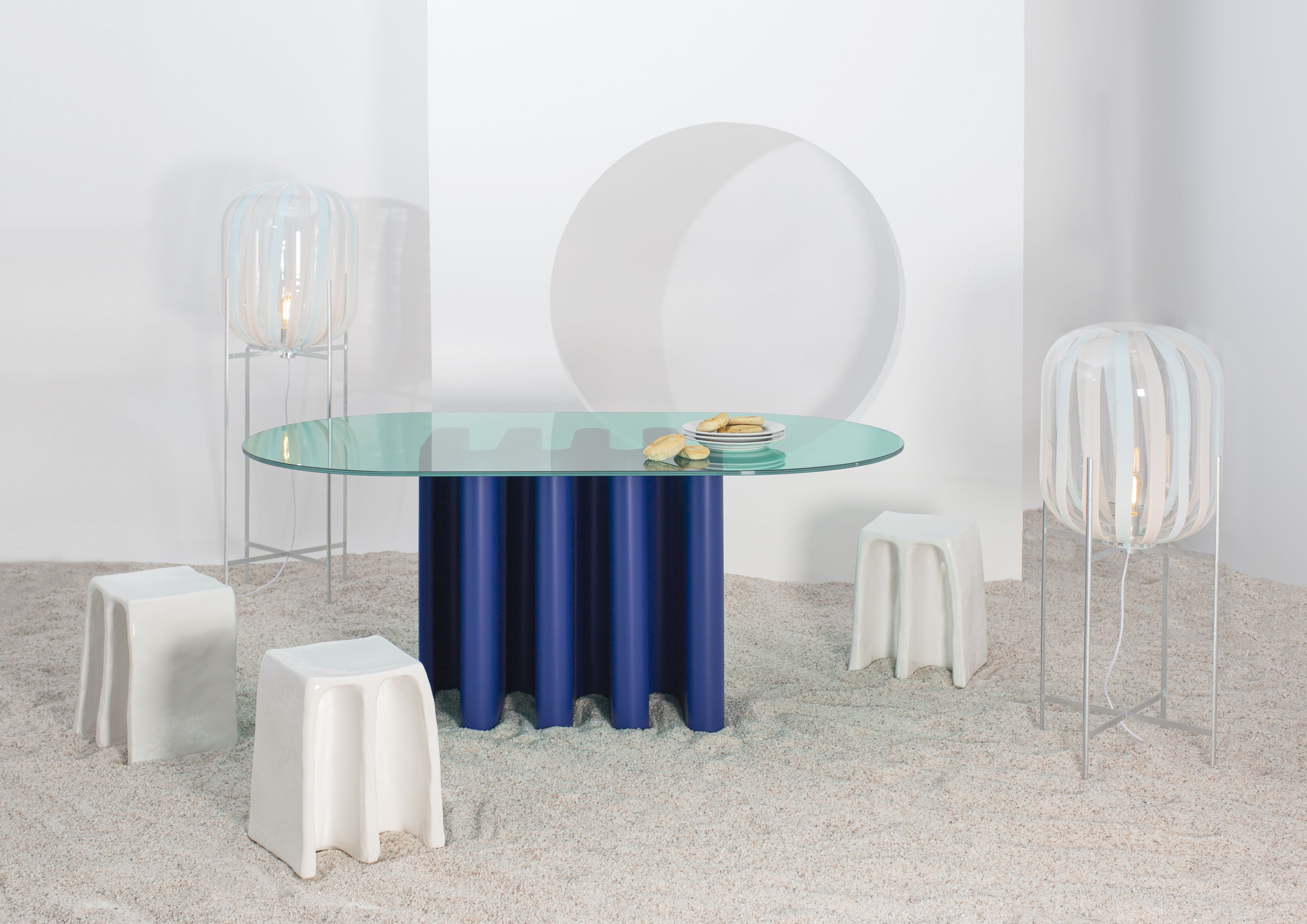 Tavolo2 Esstisch von Pulpo mit Glasplatte und blauem Säulenfuß in minimalistischem Ambiente.