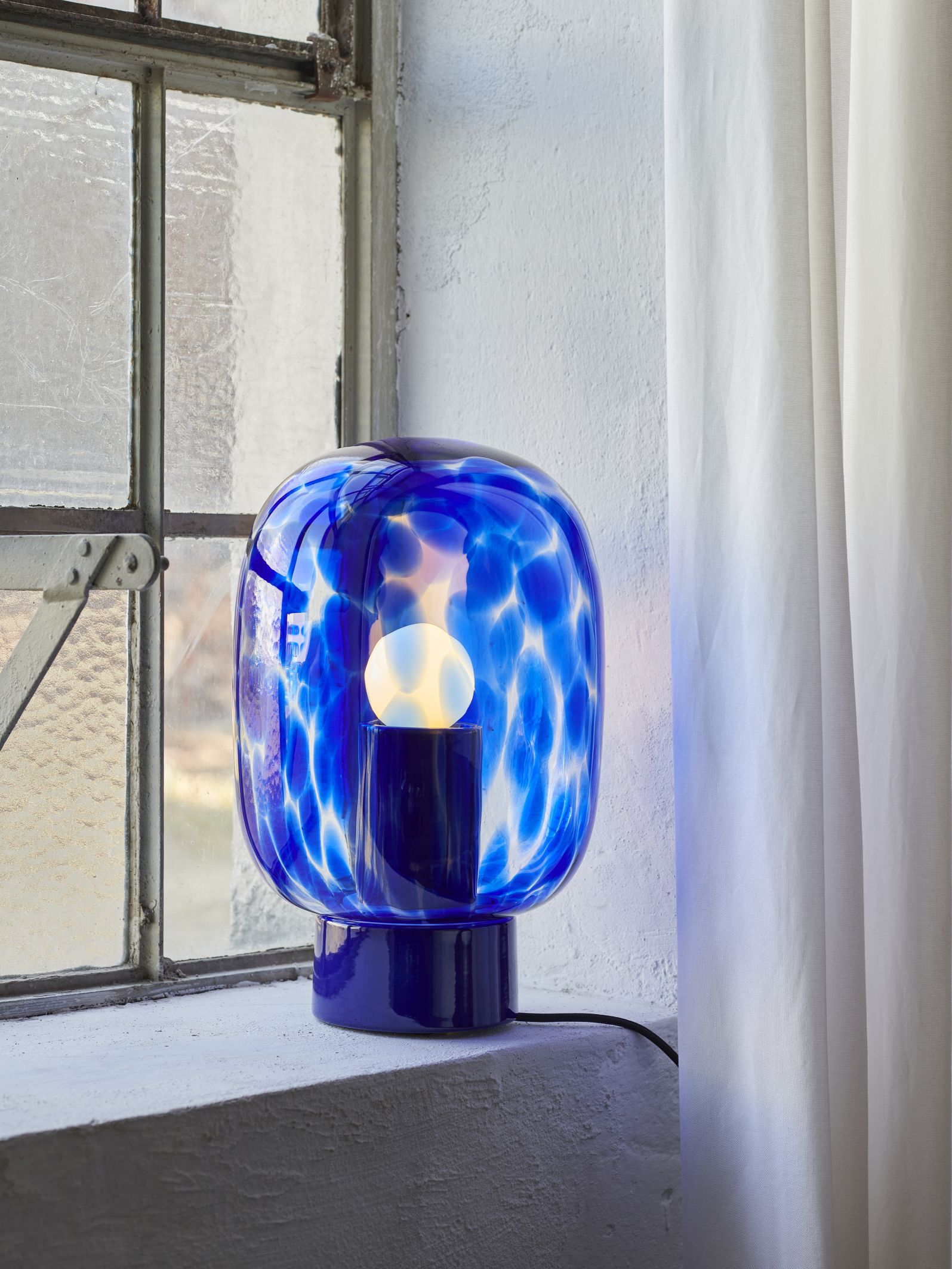 Blaue Flakes Tischleuchte mit Muster auf Fensterbank, moderne Lampe für Wohnzimmer.