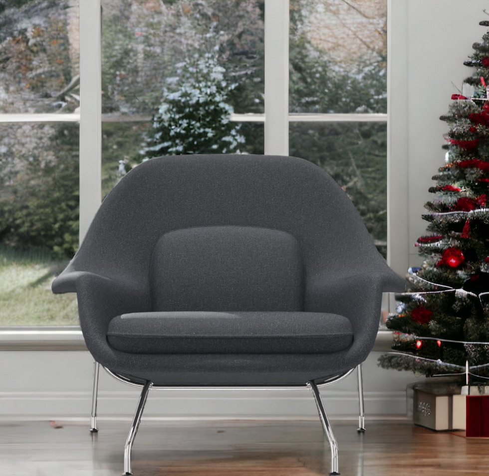 Grauer Womb Chair Sessel von Knoll International mit Chromgestell vor Fenster und Weihnachtsbaum.