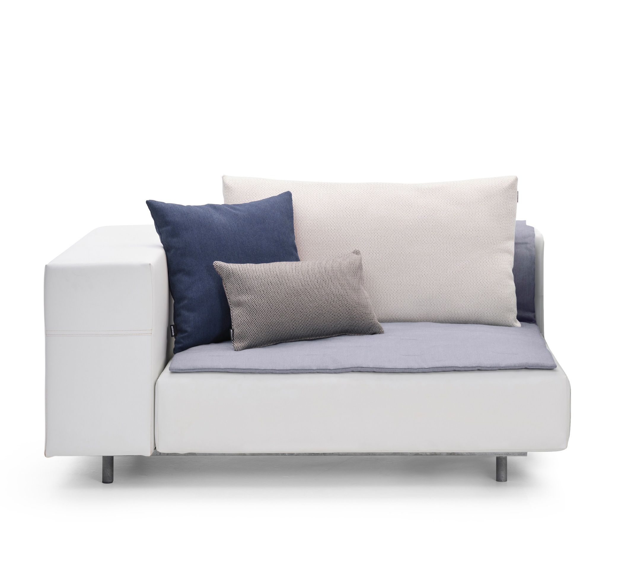 Walrus Outdoor Eckmodul von Extremis, weißes Lounge Sofa mit blauen und grauen Zierkissen.