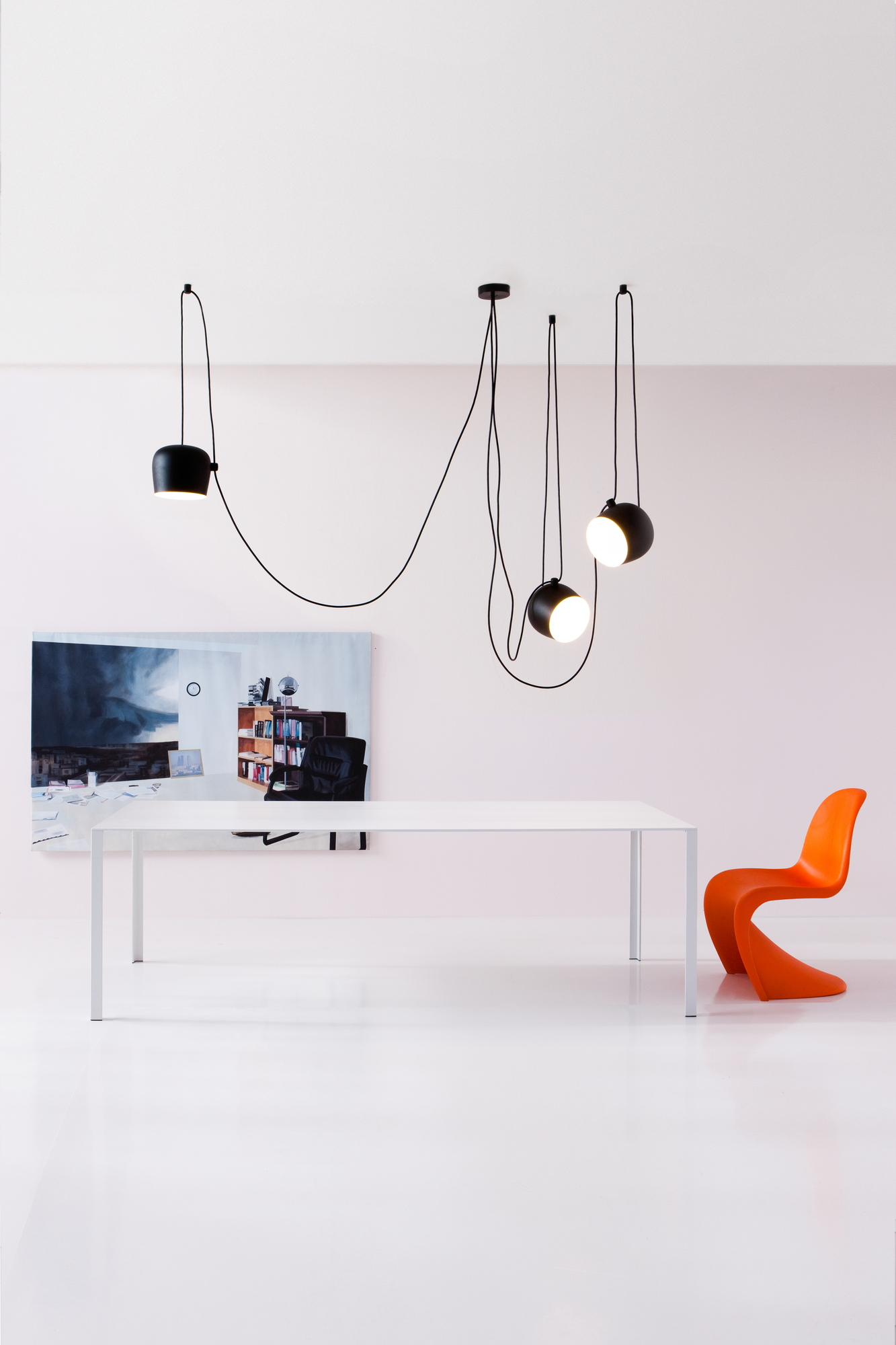 Nahaufnahme der Flos Aim Small Pendelleuchte, schwarze Hängelampe mit modernem Design über einem Esstisch.