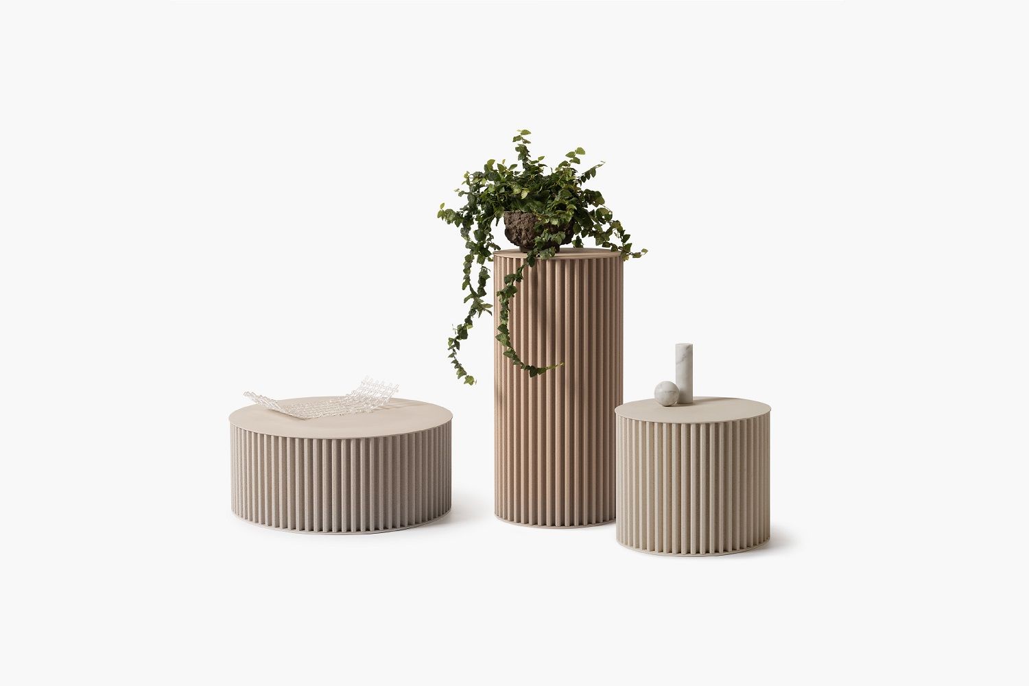 Drei Herclino Beistelltische in Taubengrau, Indoor/Outdoor geeignet, mit geriffelter Oberfläche und Deko.