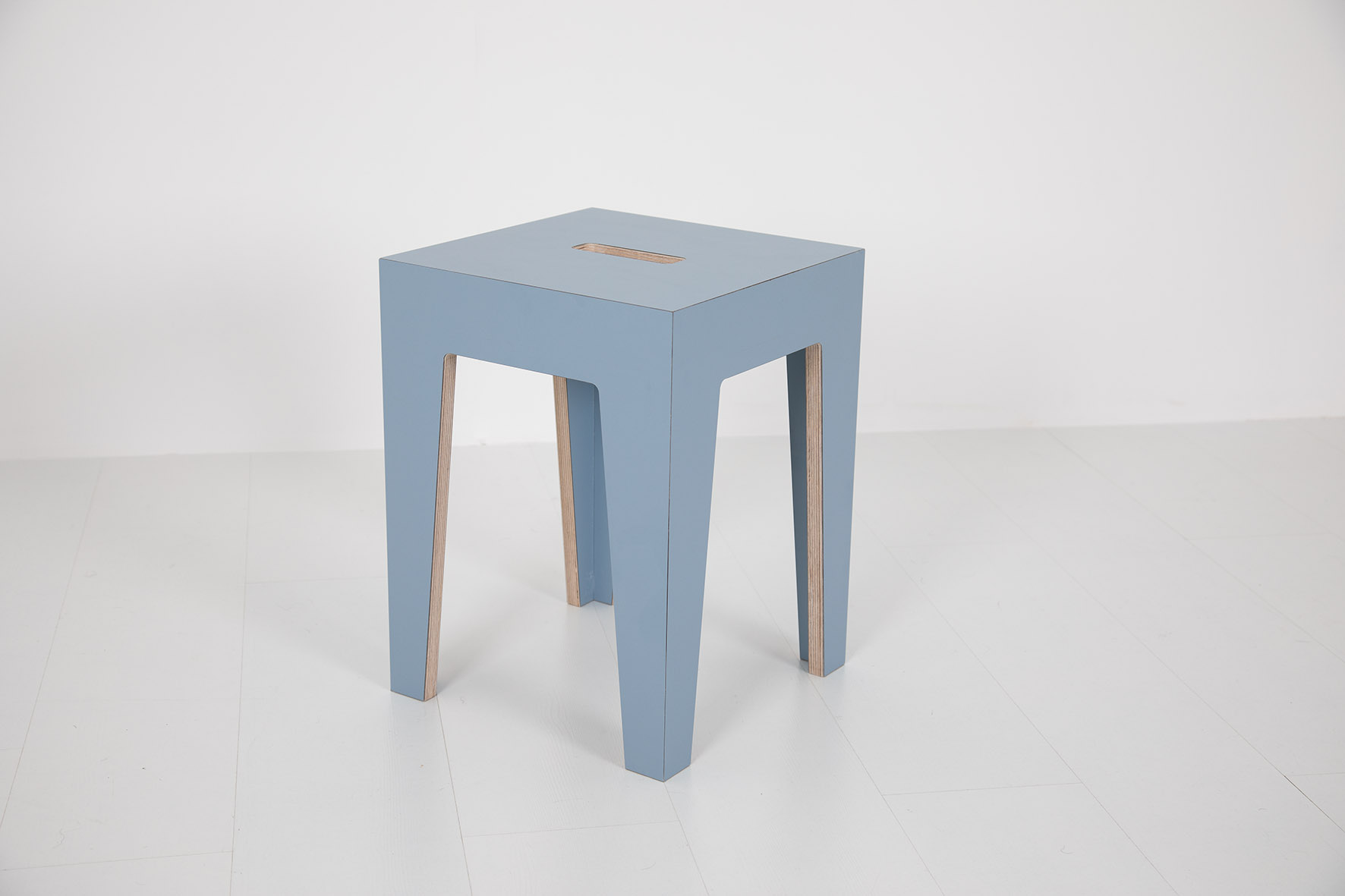 Blauer HENRIK Hocker mit quadratischer Sitzfläche und vier Beinen auf weißem Hintergrund.