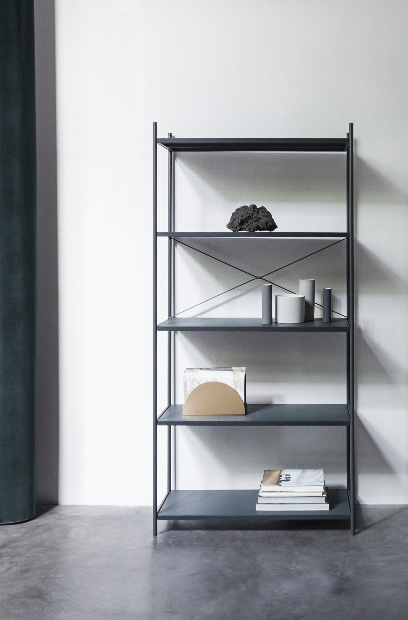 Graues Punctual Regal von Ferm Living mit fünf Fächern und Deko-Elementen vor weißer Wand.