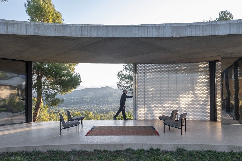 Nanimarquina Re-Rug Collection Teppich 200x300 cm in modernem Ambiente mit Person und Stühlen.