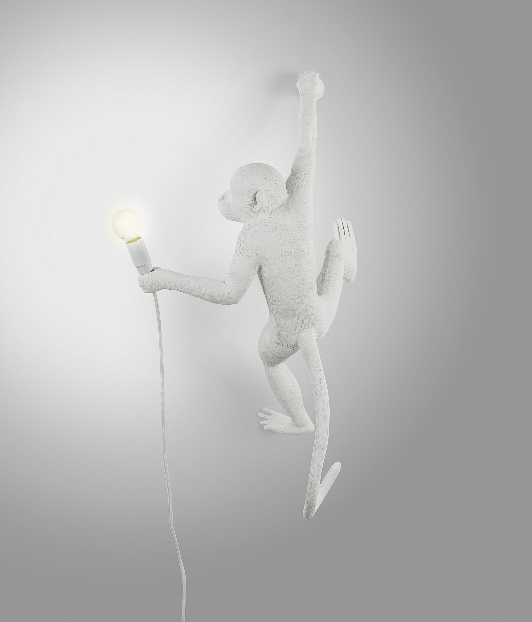 Weiße Monkey Lamp Wandleuchte (rechts) von Seletti: Affe hält eine Glühbirne an der Wand.
