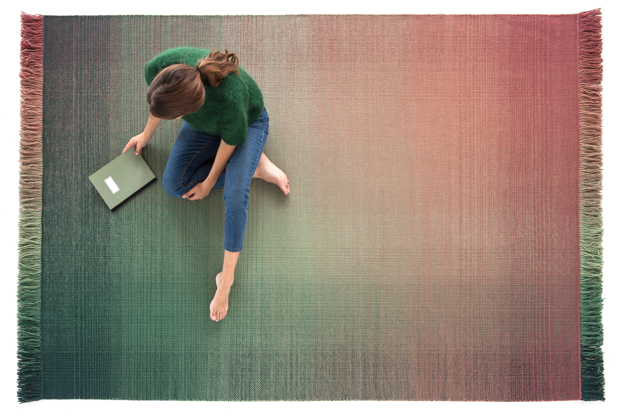 Frau auf Nanimarquina Shade Teppich 170x240 cm, Palette 1. Farbverlauf von Grün zu Rosa.