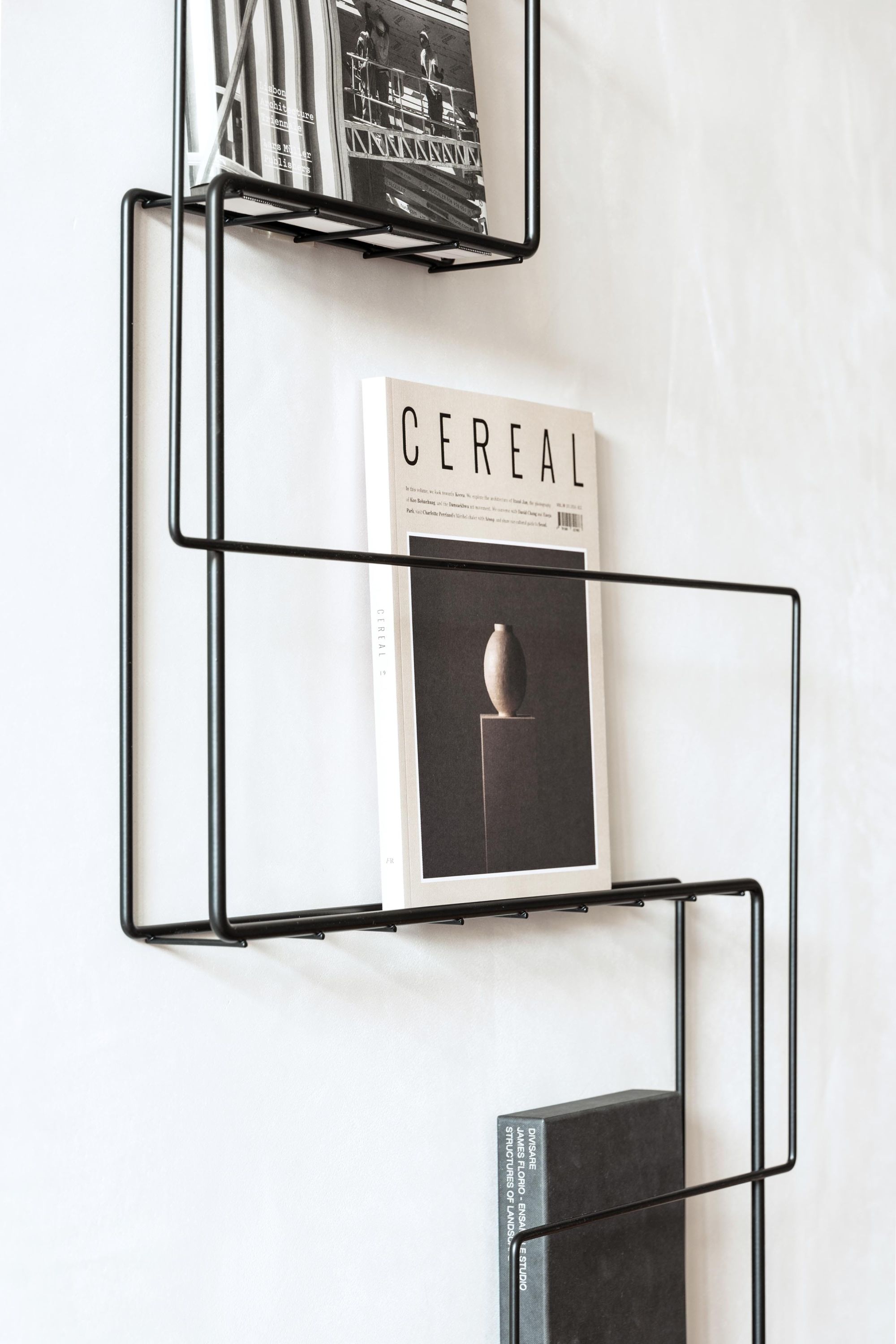 Schönbuch Revue Wand Zeitungsständer aus schwarzem Metall mit Zeitschriften und Büchern. Modernes Wandregal für Magazine.