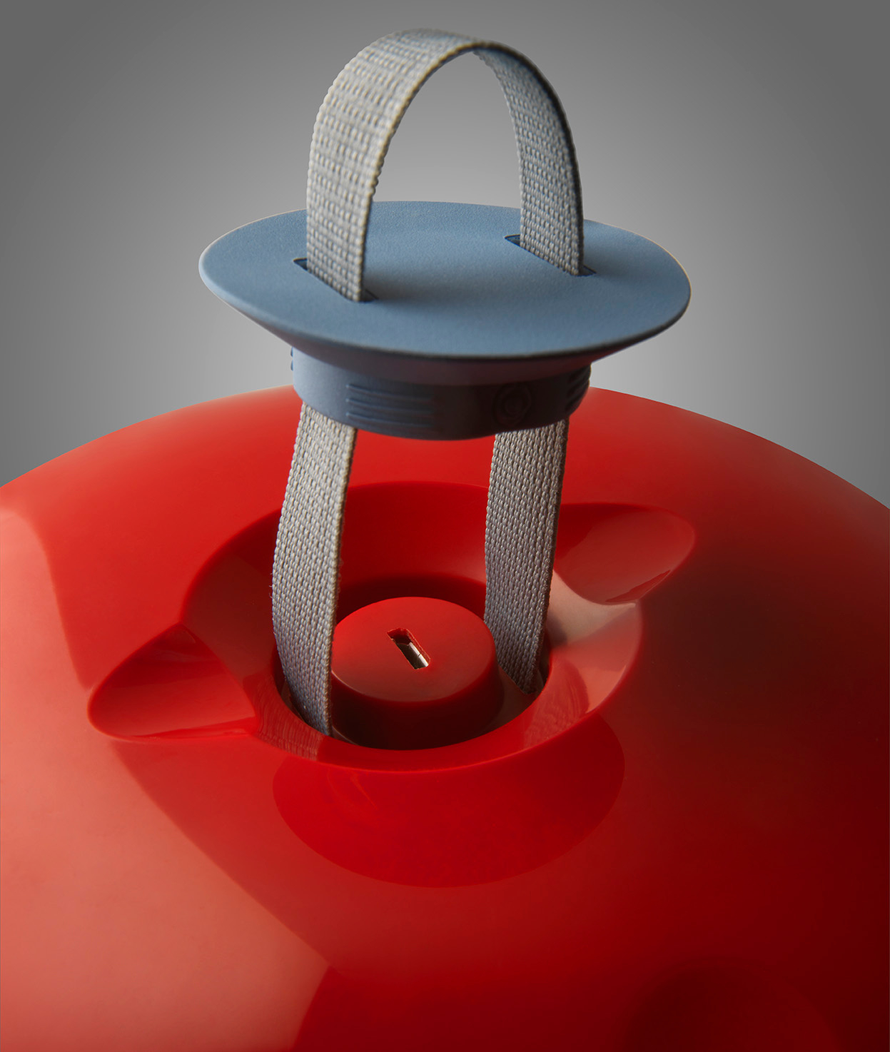 Detailaufnahme der roten Cri Cri Tischleuchte von Foscarini mit Tragegriff. Design Lampe für Innenräume.