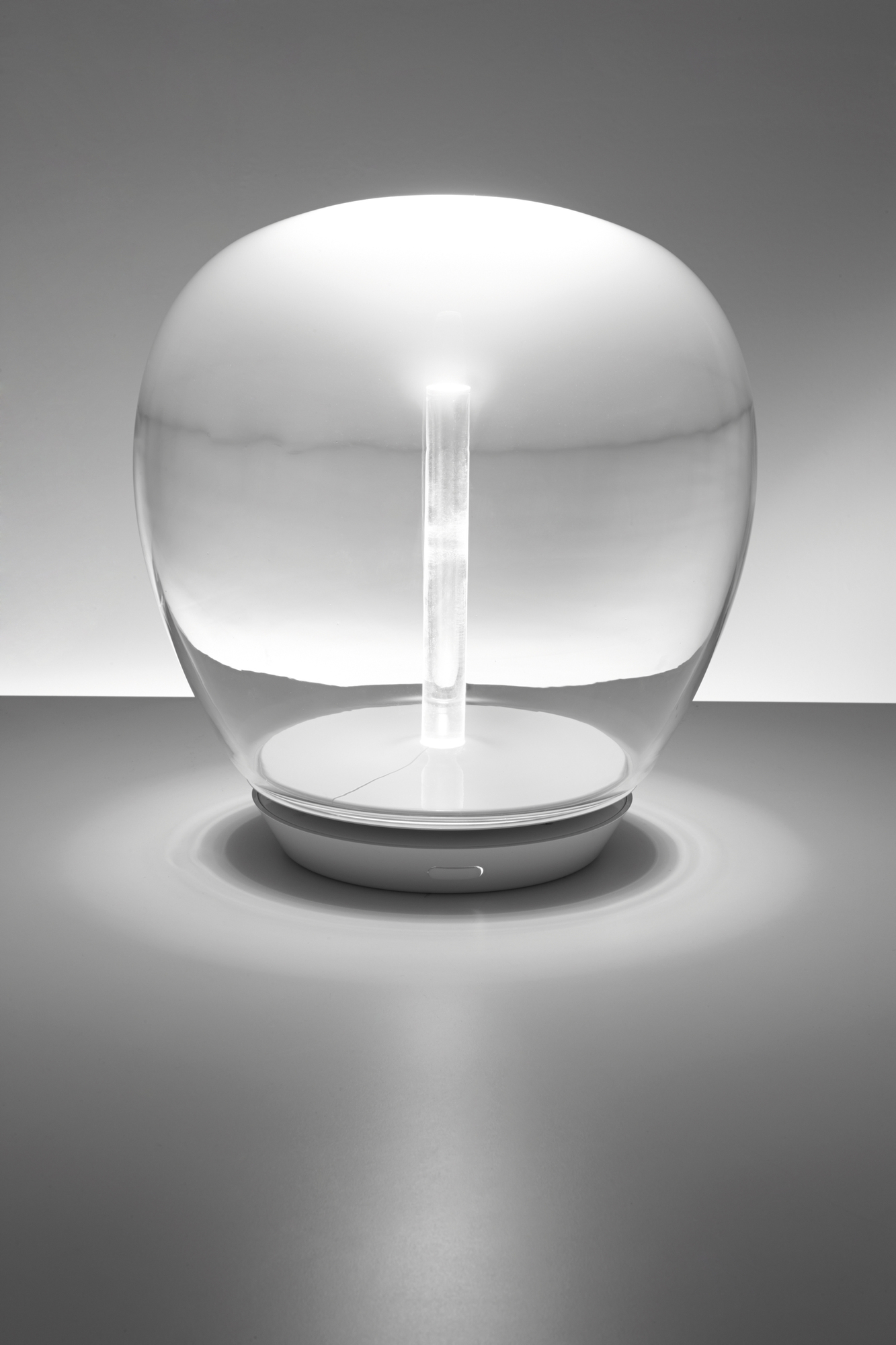 Empatia Tischleuchte von Artemide: Moderne Lampe mit transparentem Glaskörper und zentralem Leuchtstab.