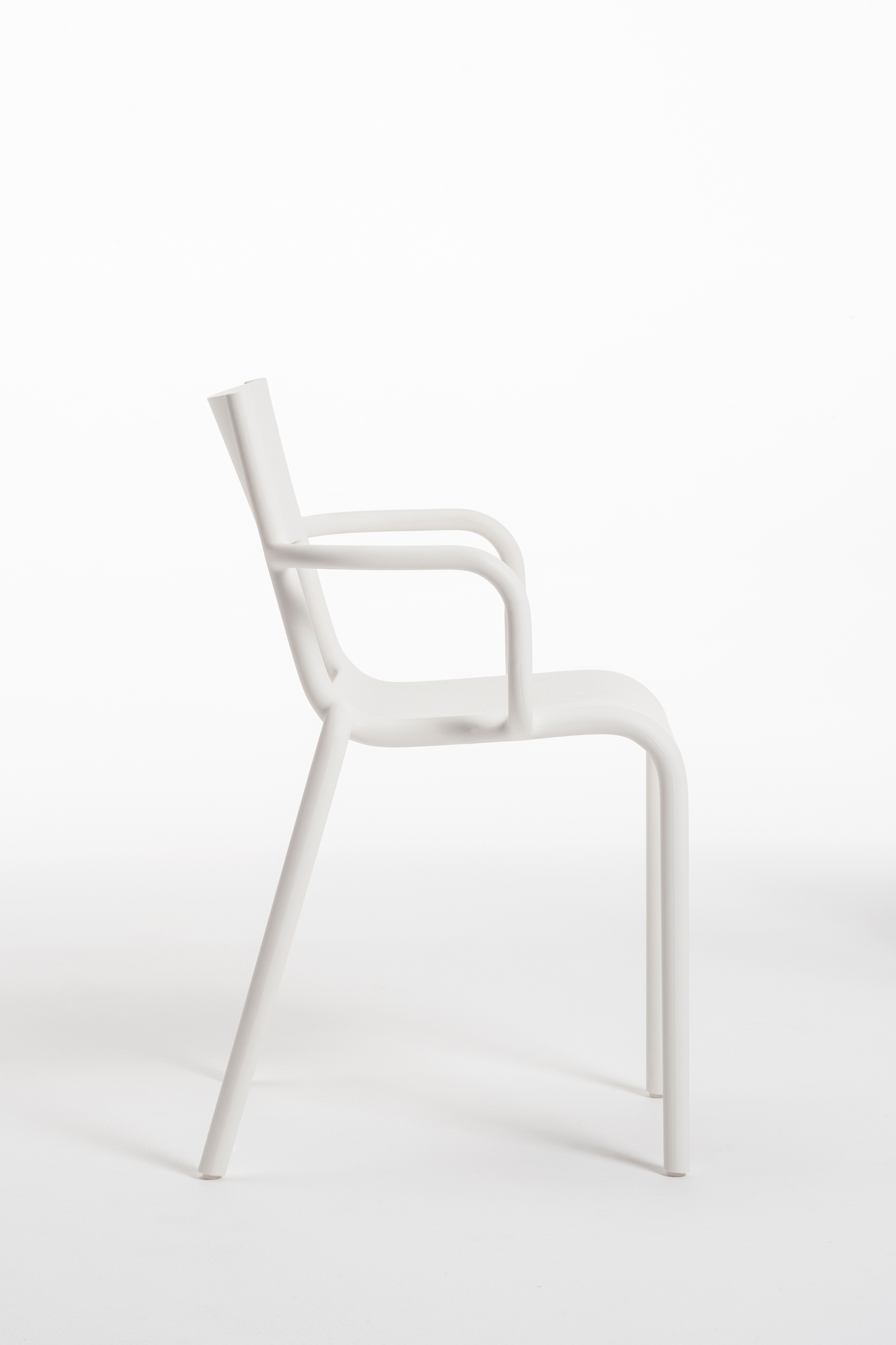 Schwarzer A Armlehnstuhl im Kartell-Stil, moderner Designstuhl aus Kunststoff, Seitenansicht auf weißem Hintergrund.