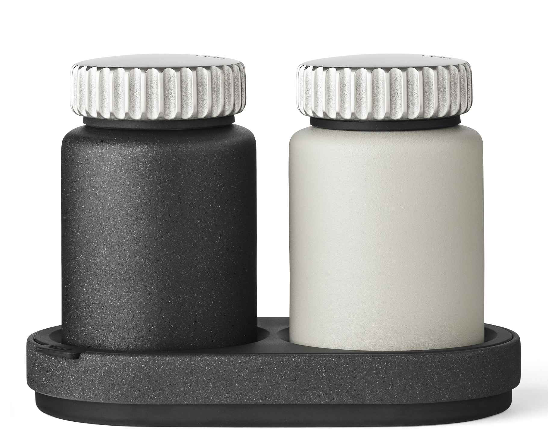 Vipp Salz- und Pfeffermühle Set in Schwarz und Weiß auf dunklem Tablett.