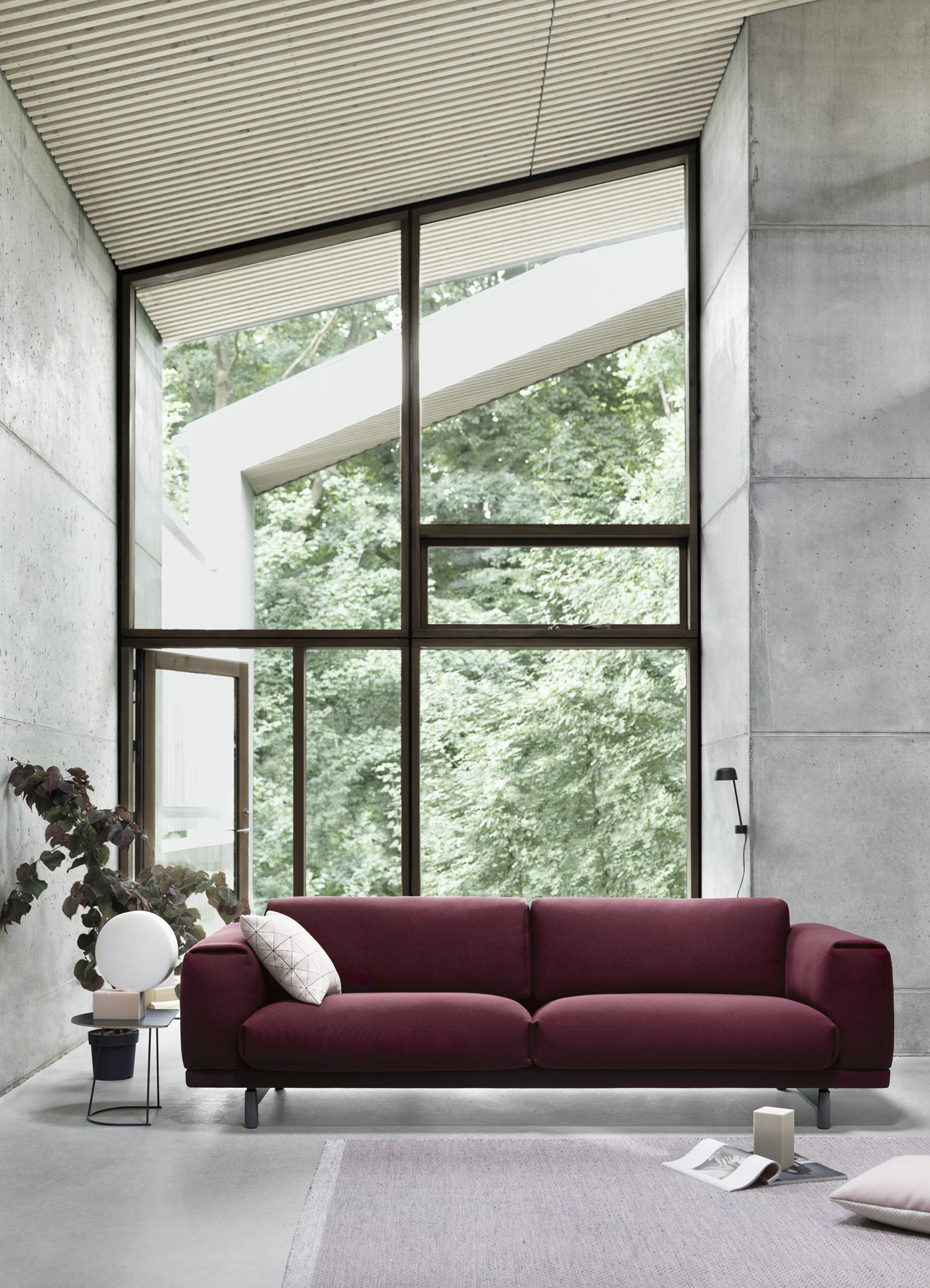 Burgunderrotes Muuto Rest Sofa, ein 3-Sitzer, in modernem Wohnzimmer mit großem Fenster.