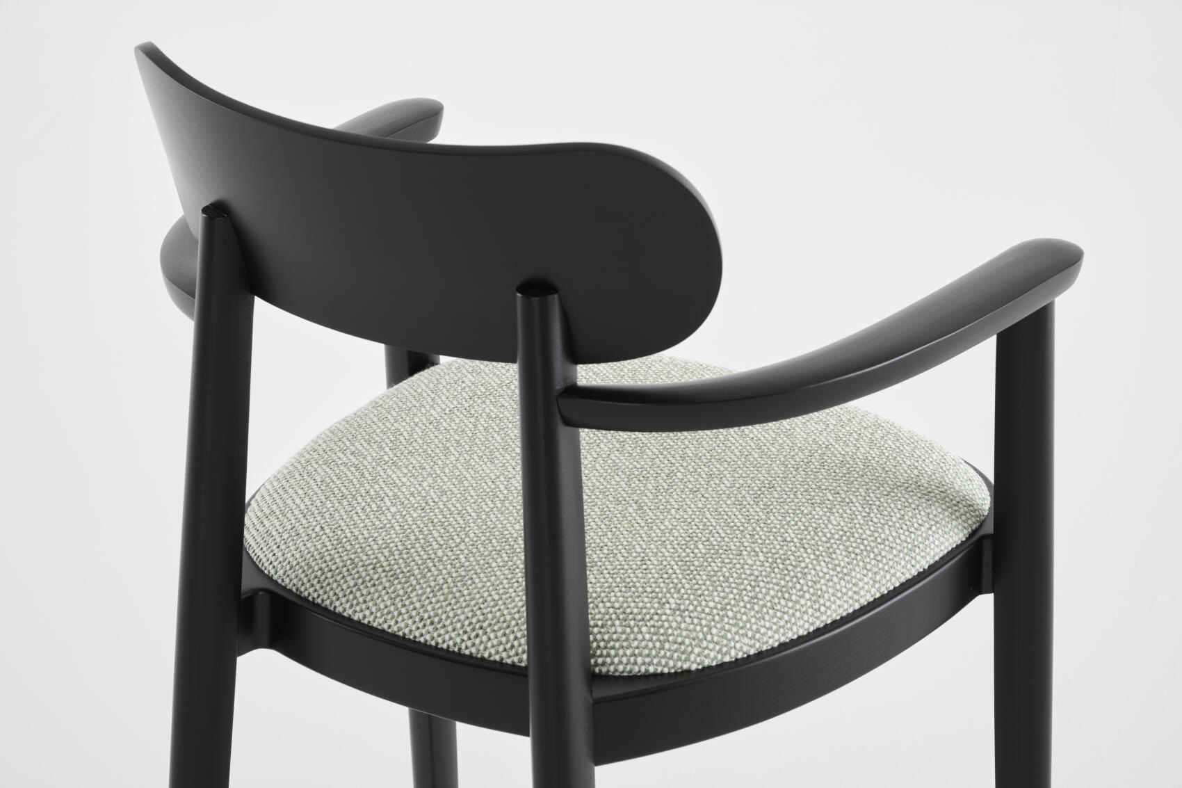 Detailaufnahme: Schwarzer 118 SPFV Holzstuhl mit Armlehnen und hellgrauem Stoffbezug von Thonet.