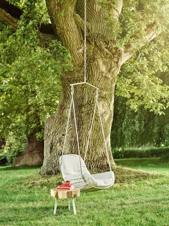 Leyasol Lounge Schwingsessel von Freifrau Manufaktur im Garten unter einem Baum. Bequemer Outdoor Sessel.