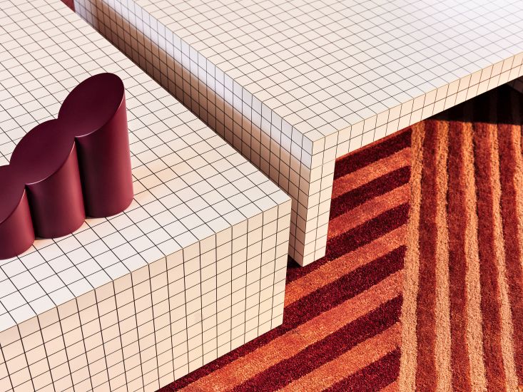 Quaderna Couchtisch von Zanotta mit Rastermuster und rotem Teppich, modernes Design für Wohnzimmer.