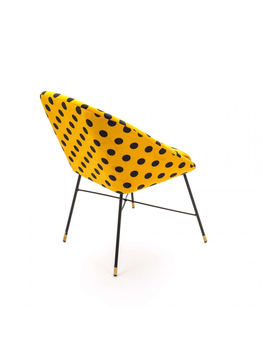 Toiletpaper Polsterstuhl Shit Seletti, gelber Design Stuhl mit schwarzen Punkten und schwarzen Metallbeinen.