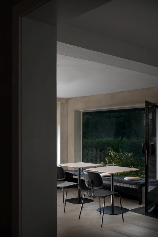 Zwei quadratische Vermu Esstische von Zeitraum mit schwarzen Stühlen in einem hellen Raum mit Fenster.