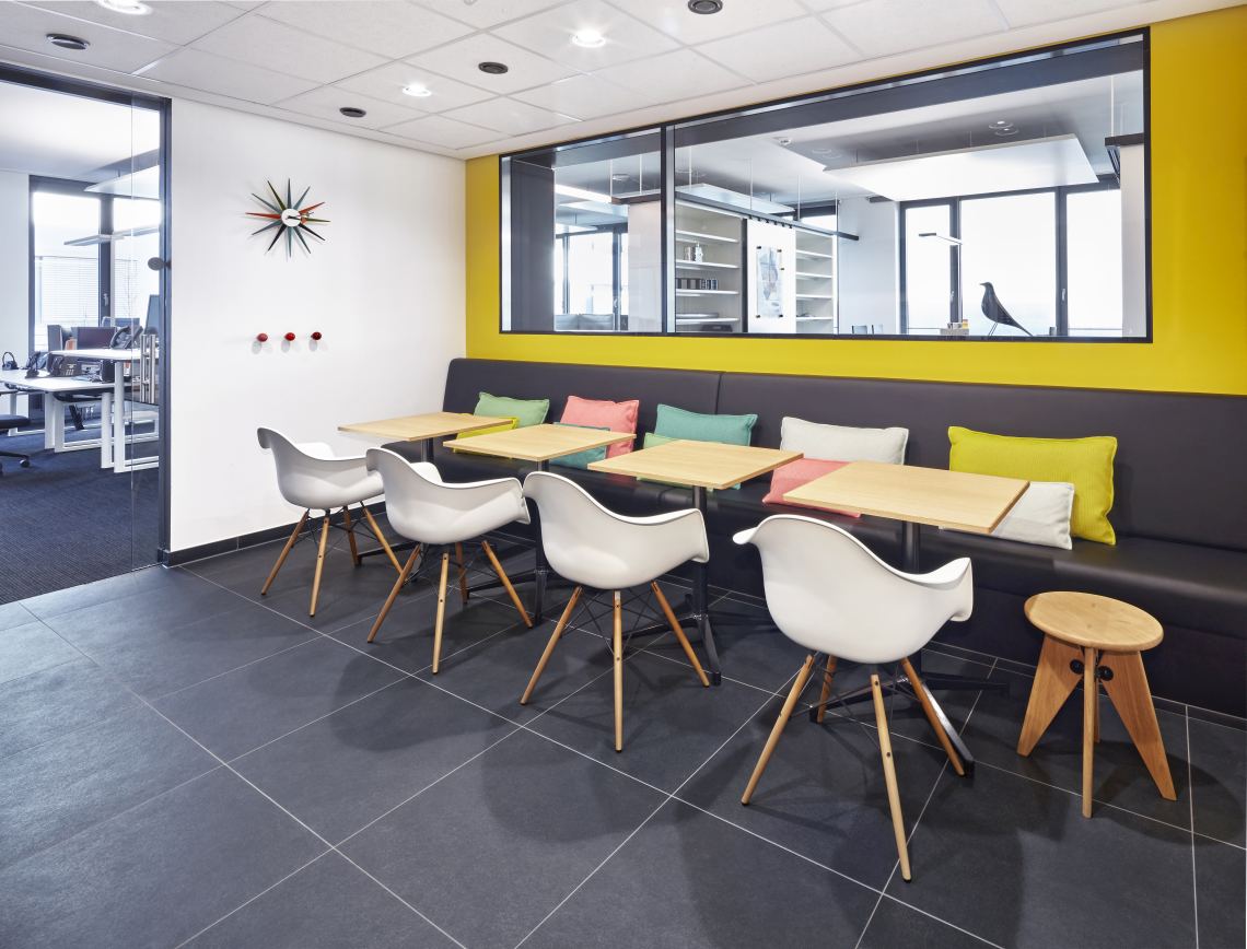 Innenaufnahme: Rechteckiger Bistro Table Tisch von Vitra mit weißen Stühlen und Sitzbank.