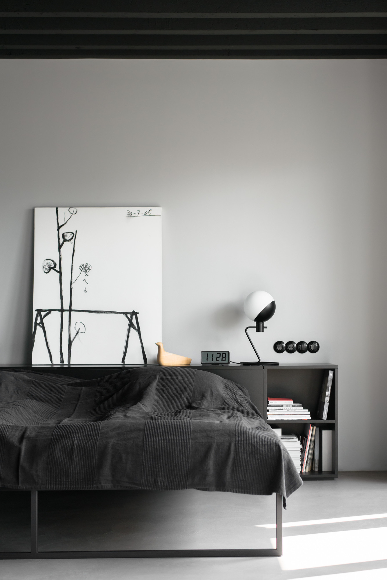 Schlafzimmer mit Baluna Tischleuchte von Grupa, Nachttisch, Bett und minimalistischer Dekoration.