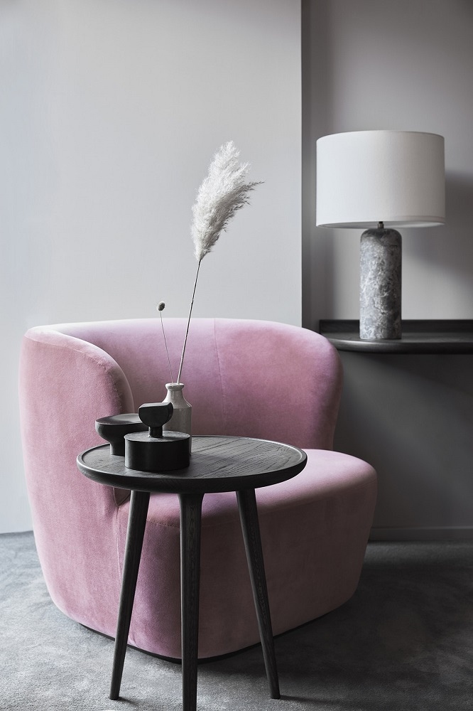 Eleganter Accent Beistelltisch aus Eiche, schwarz gebeizt, neben einem rosa Sessel. Dekorative Wohnaccessoires.