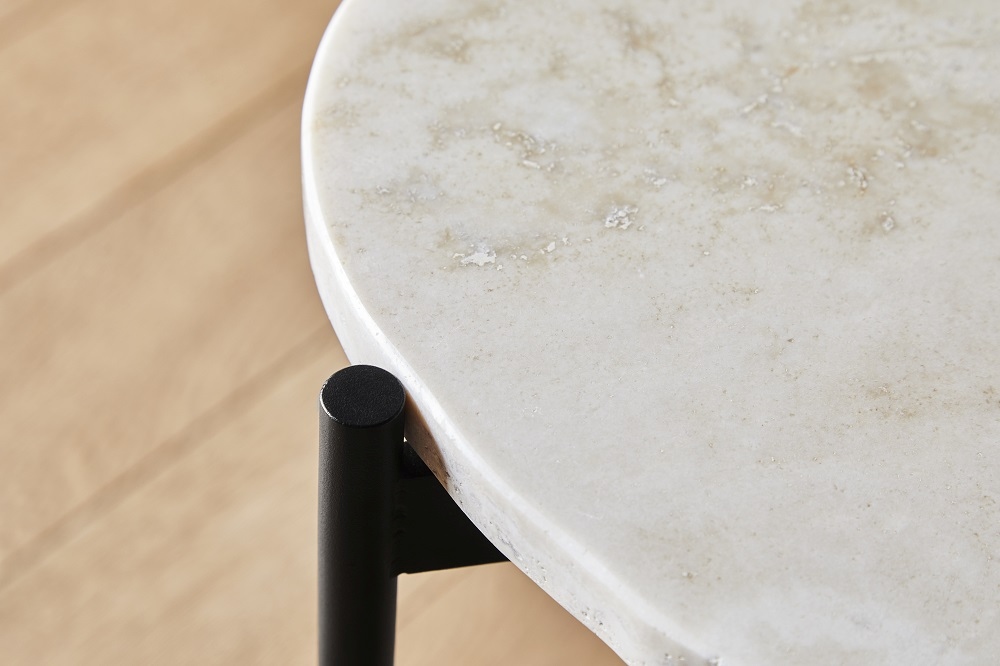 Detailaufnahme: La Terra Couchtisch Woud, große elfenbeinfarbene Marmorplatte mit schwarzem Metallfuß.