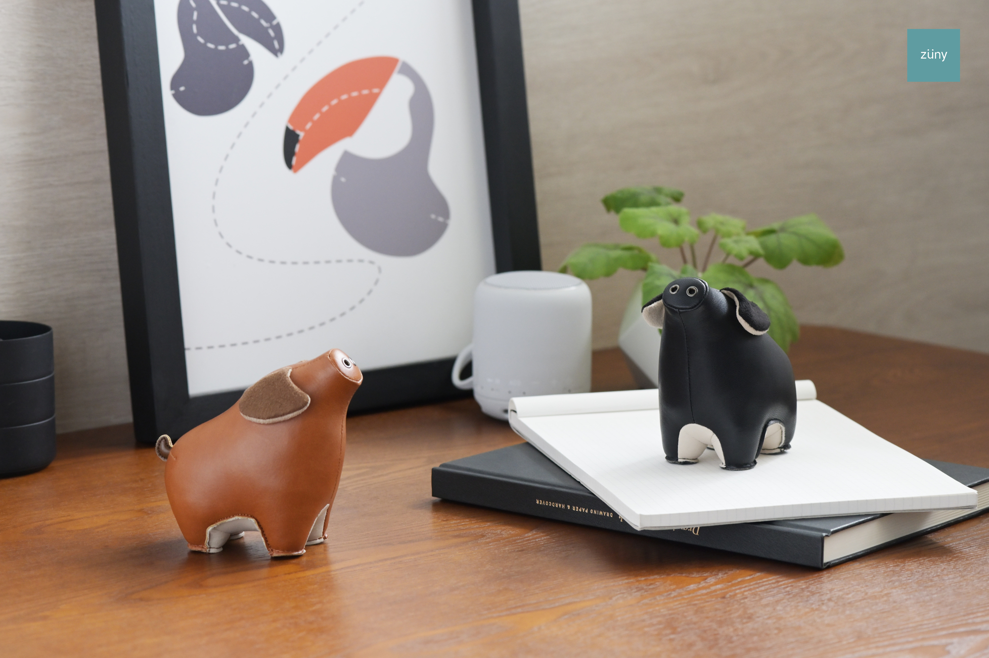 Zwei Züny Schwein Briefbeschwerer: Schwarz und Weizen, dekorative Buchstützen aus Kunstleder.