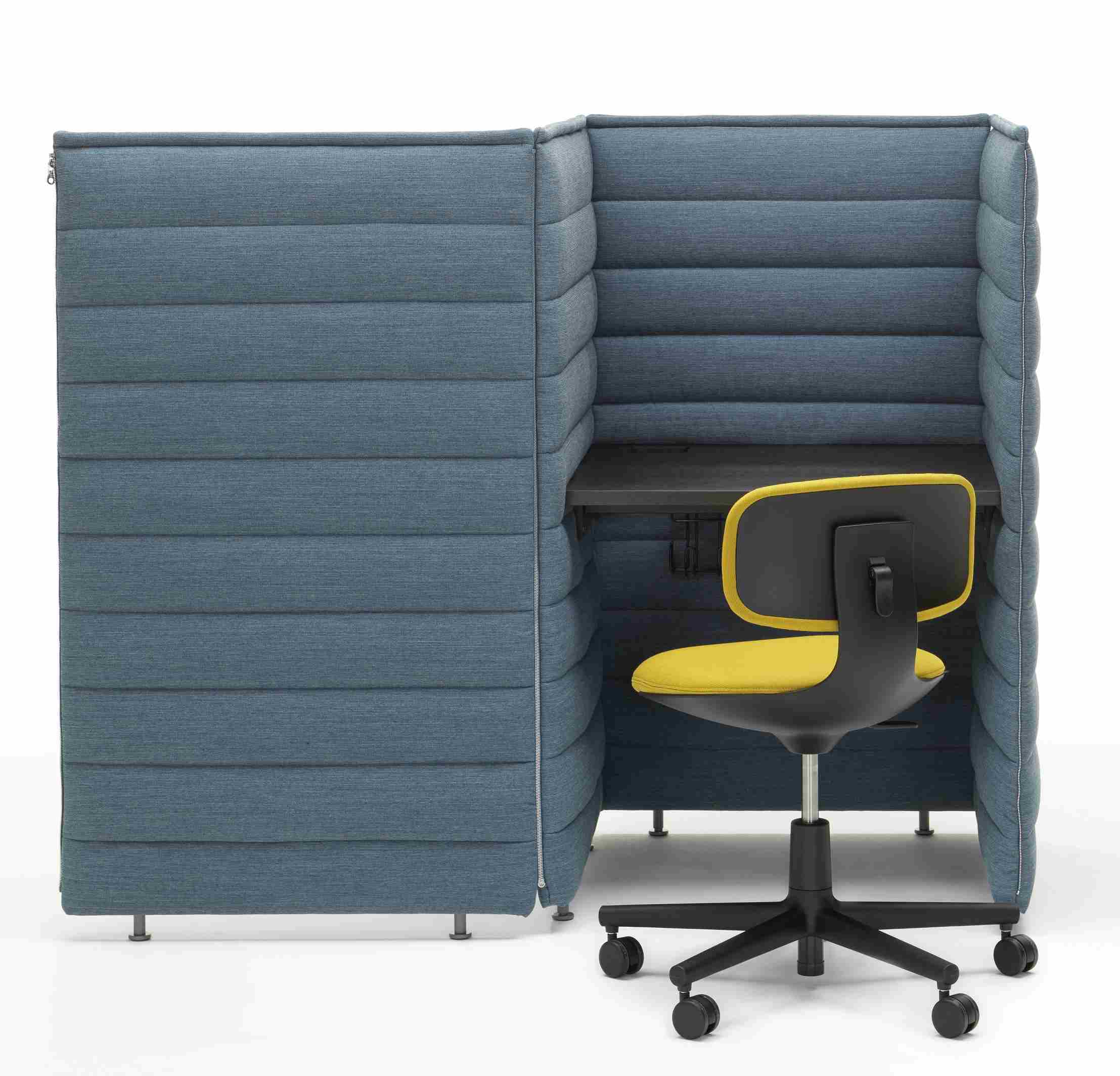 Vitra Alcove Schreibtisch mit blauen, gepolsterten Wänden und gelbem Bürostuhl für konzentriertes Arbeiten.