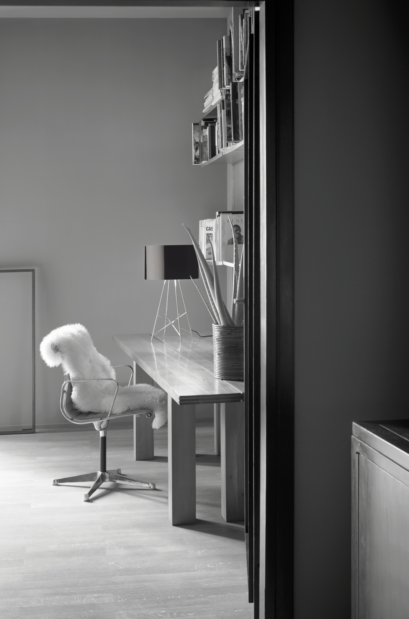 Ray T LED Tischleuchte von Flos auf Schreibtisch in modernem Arbeitszimmer, schwarz-weiß.