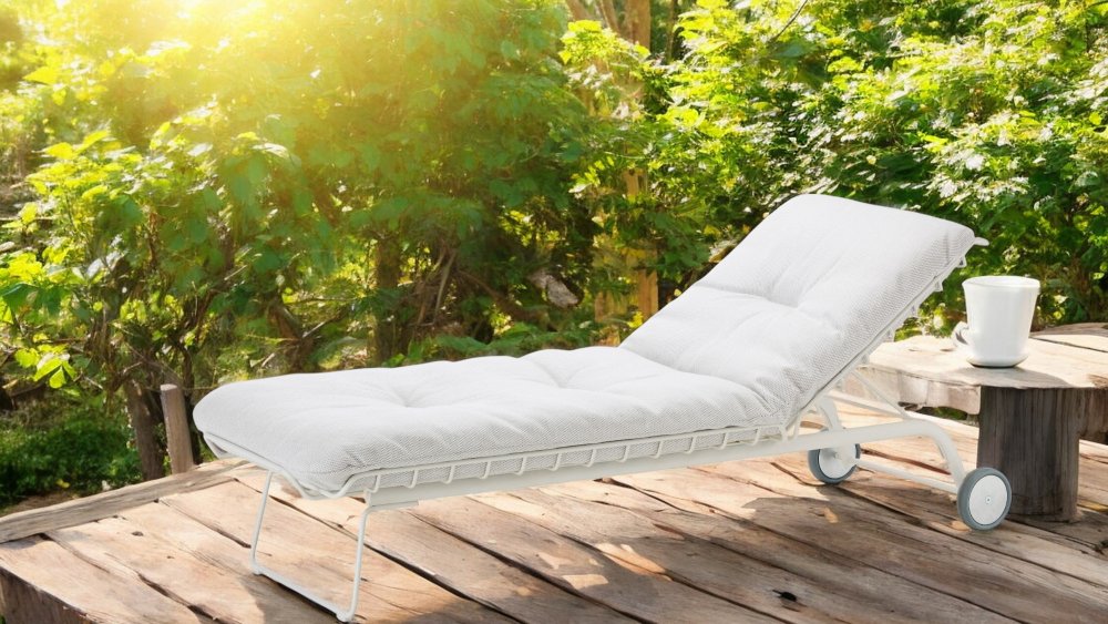 Weiße Leyasol Sonnenliege von Freifrau Manufaktur für den Garten oder Innenbereich auf Holzterrasse.