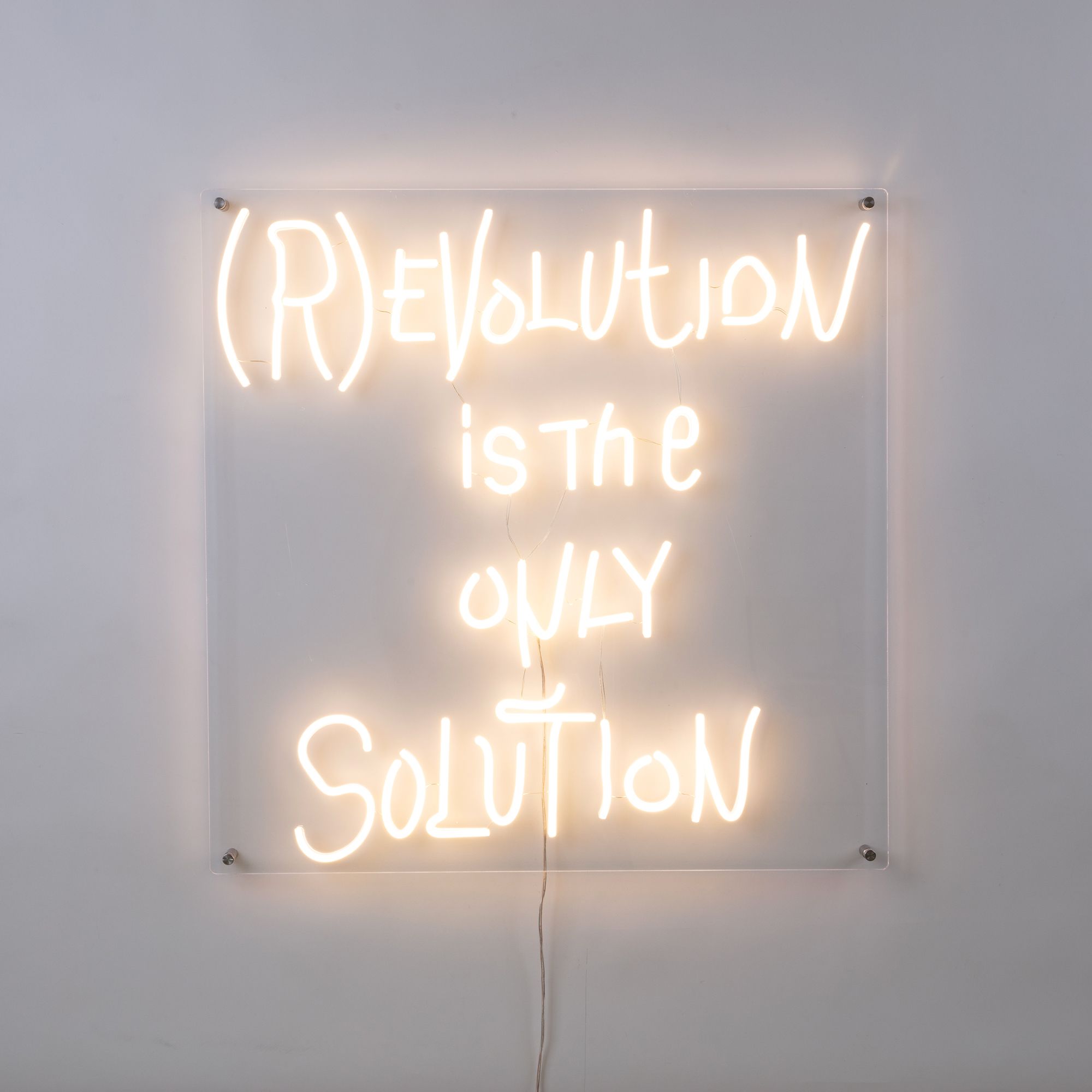 Seletti Revolution LED Wandleuchte: Leuchtendes Neon-Zitat "(R)Evolution is the only Solution" auf transparentem Acryl.