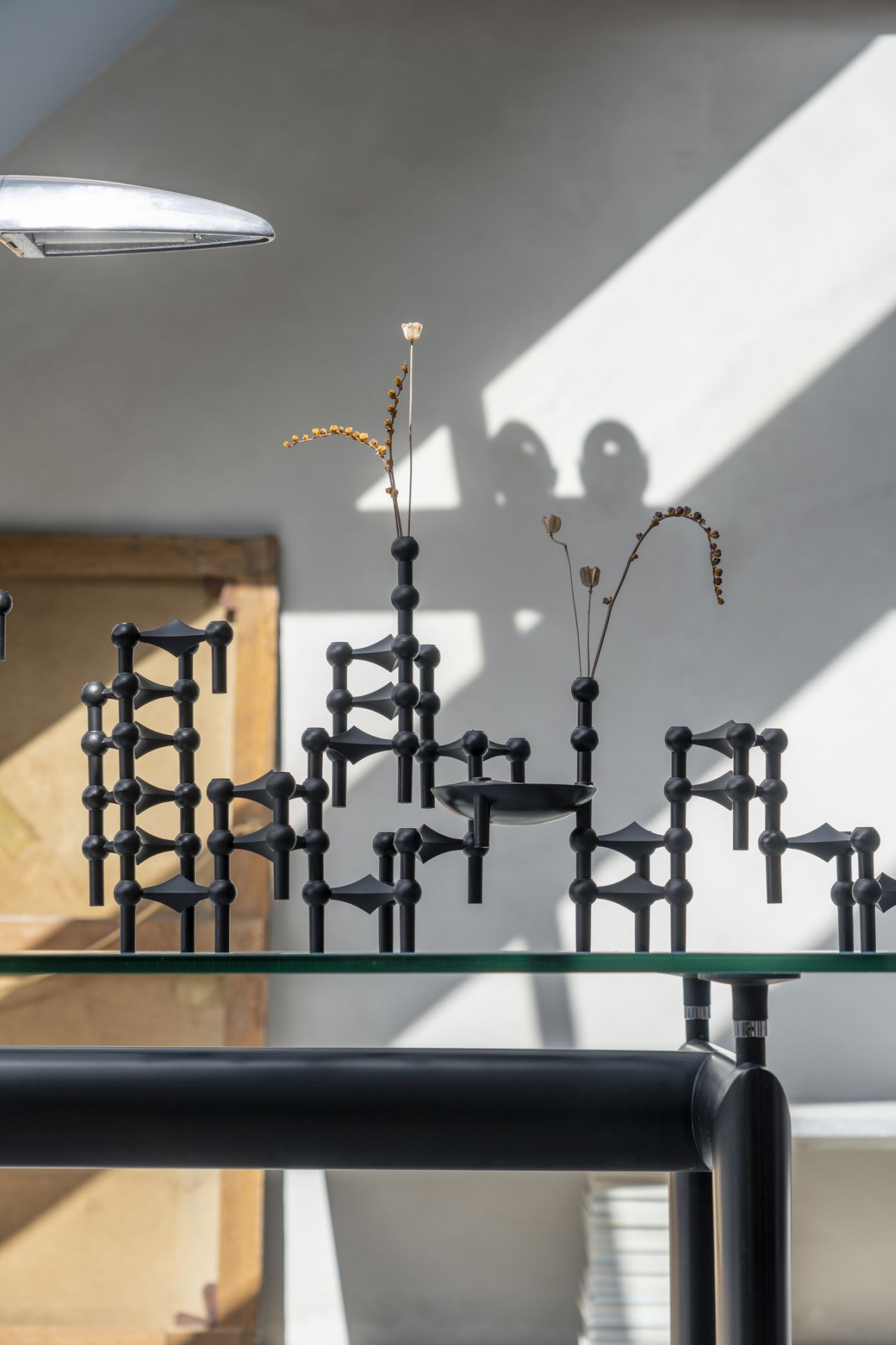 Schwarzes Kerzenständer 3er Set im Stoff Nagel Design auf einem Glastisch, moderne Dekoration.