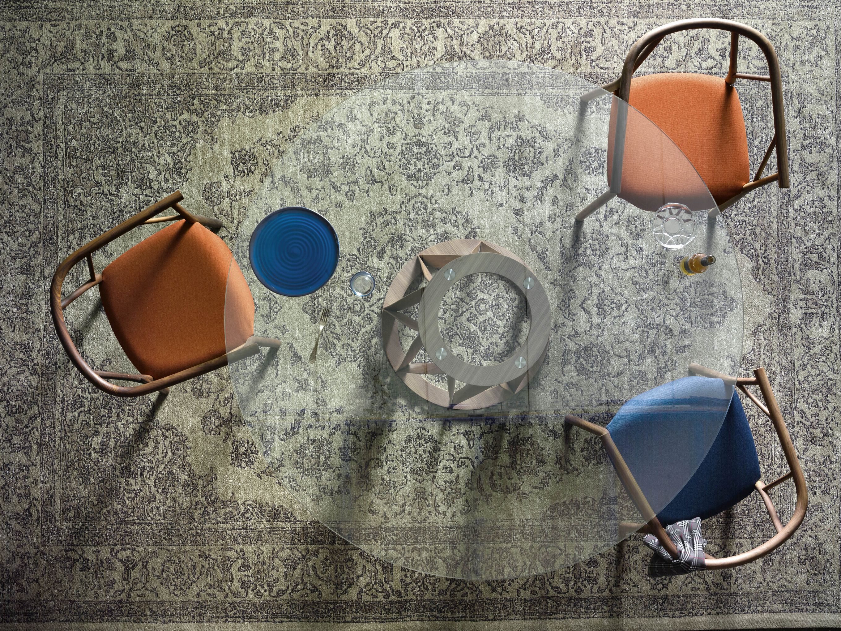 Draufsicht auf Acco Tisch Glas Miniforms mit Stühlen, Geschirr und Dekoration auf einem Teppich.