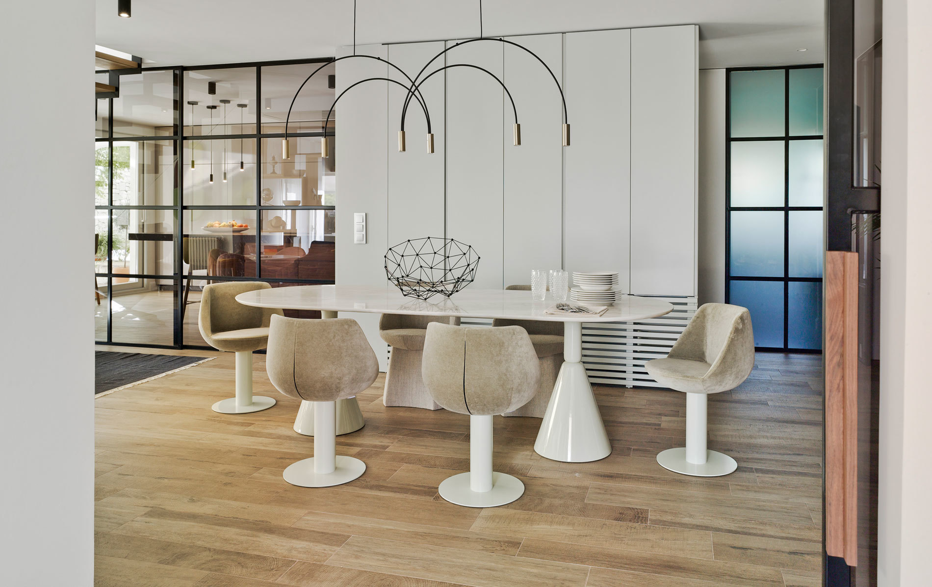 Ovaler Esstisch von Sancal mit Stühlen und moderner Lampe in einem hellen Esszimmer.