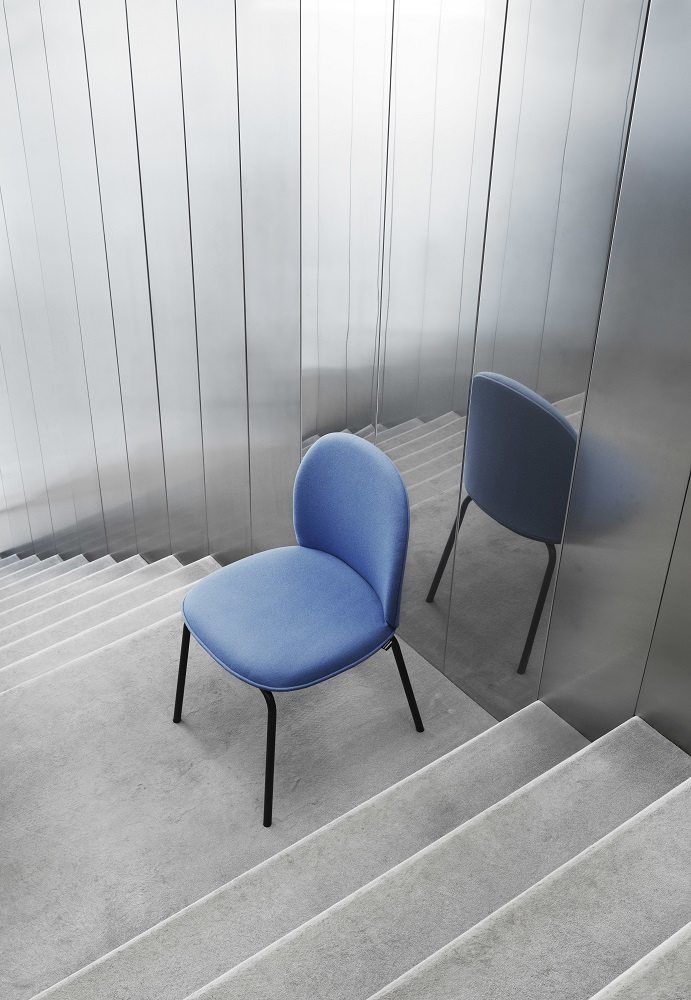 Blauer Ace Chair Stuhl von Normann Copenhagen mit schwarzen Beinen auf einer Treppe.