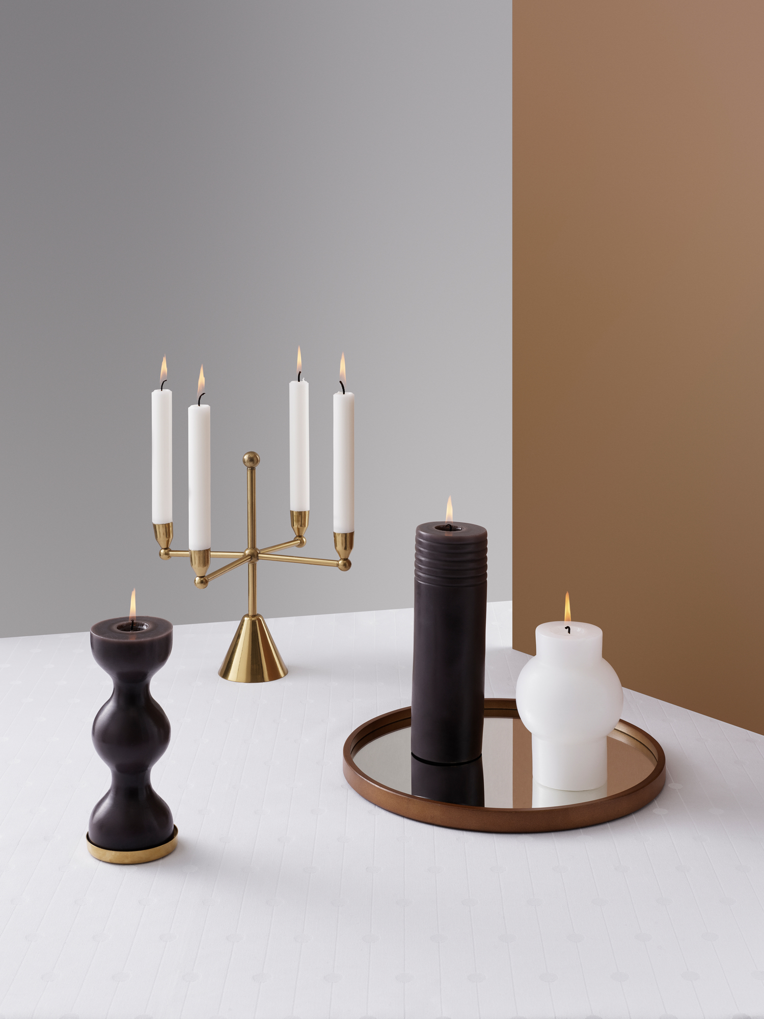 Produktfoto: Pirouette Kerzenhalter von Normann Copenhagen, goldener Kerzenständer und moderne Stumpenkerzen. Dekorative Kerzen für stimmungsvolle Beleuchtung.