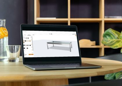 Laptop zeigt USM Haller Tisch Konfigurator für individuelle Büromöbel und Design Tische.