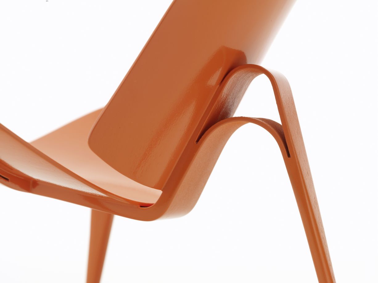 Detailaufnahme: 3-benet Skalstol Miniatur, orangefarbener Design Stuhl mit drei Beinen, Vitra Sammlerstück.