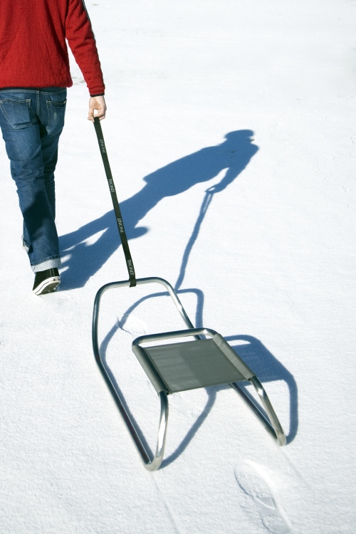 Mann zieht Thonet S 333 Schlitten im Schnee, limitierte Edition, Designschlitten.