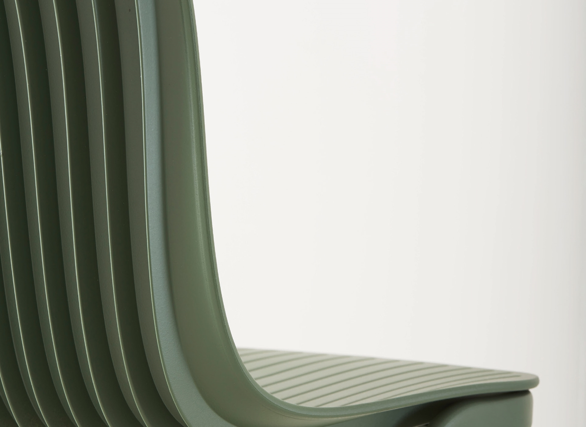 Detailaufnahme: Grüner Dragonfly Stuhl von Segis, stapelbarer Designstuhl für Büro und Wohnbereich.