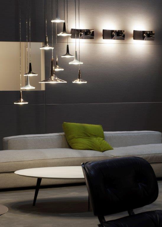 Kin LED Pendelleuchte von Oluce: Moderne Hängeleuchten in Silber über Sofa und Tisch.