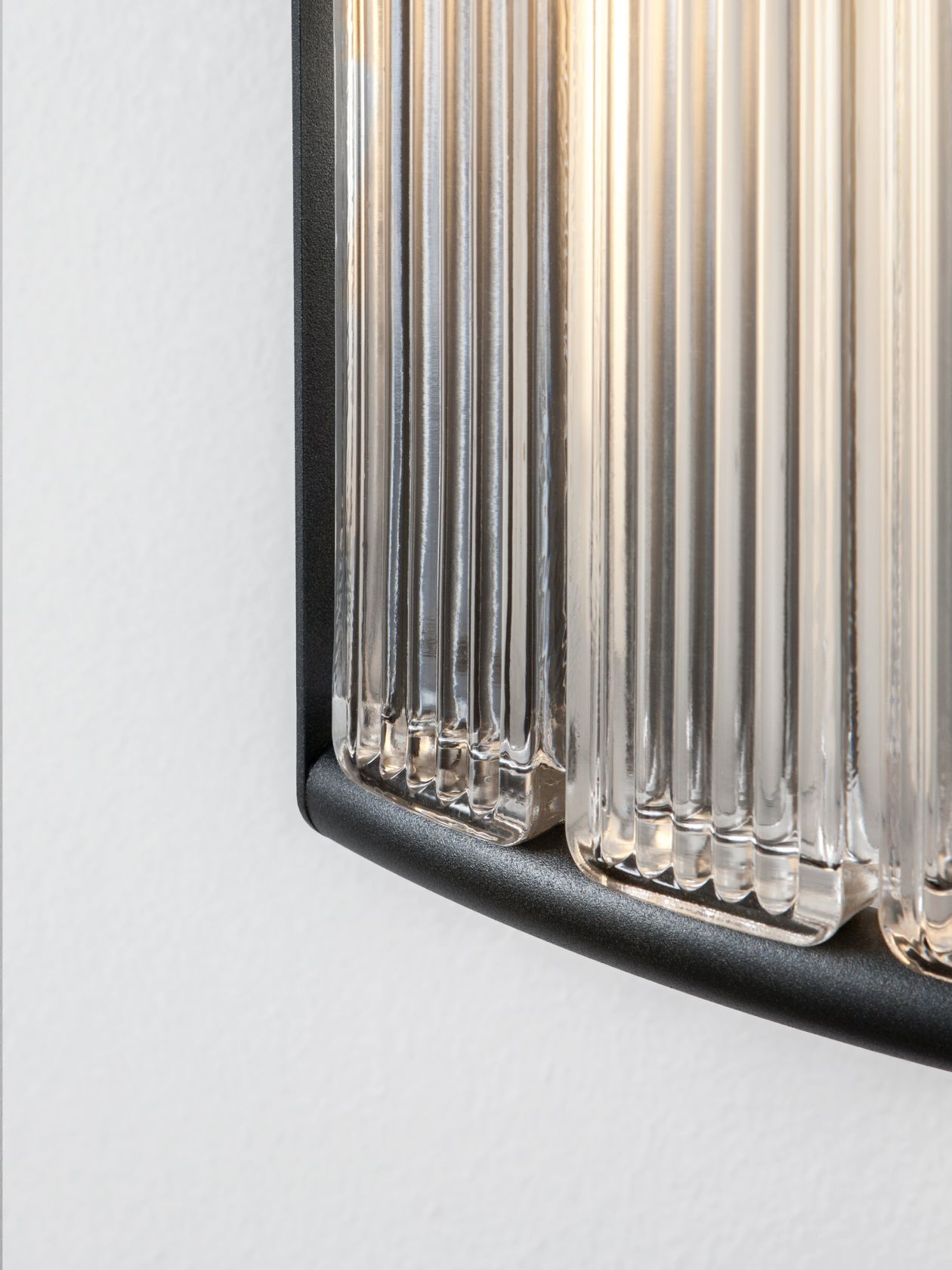 Detailaufnahme der Estadio Wandleuchte von Santa & Cole mit geriffeltem Glas und schwarzem Rahmen.