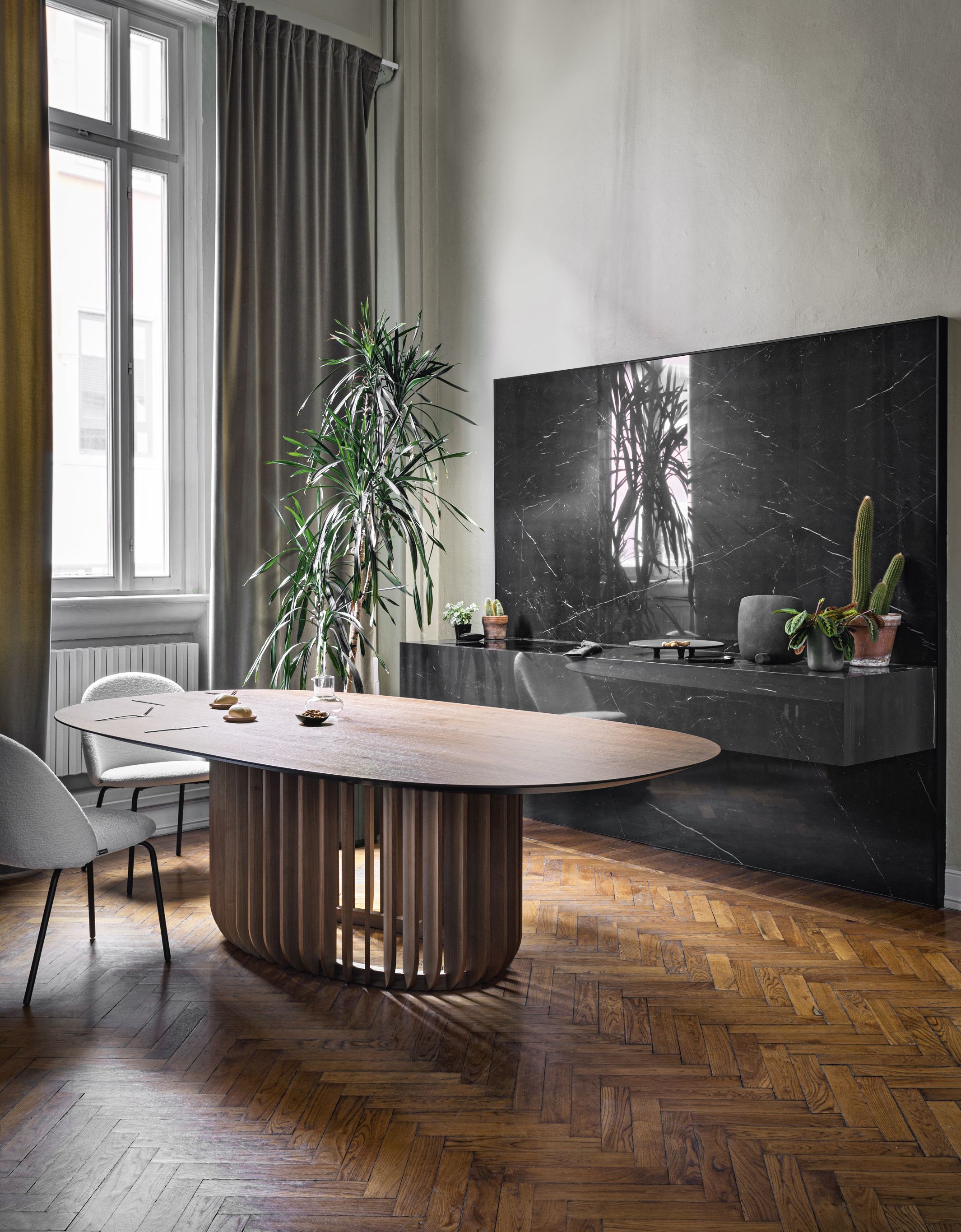 Juice Tisch von Miniforms im Esszimmer: Ovaler Holztisch mit geripptem Sockel und Stühlen.