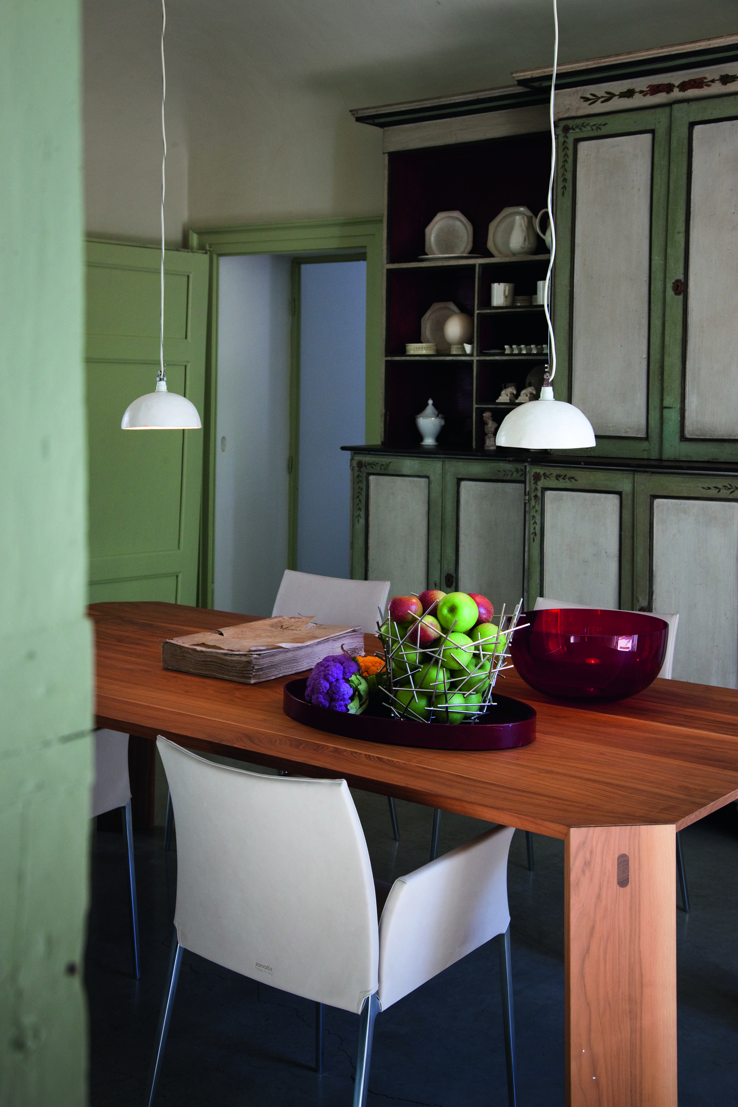 Esszimmer mit Holztisch und weißen Lia Stühlen von Zanotta mit Armlehnen. Modernes Design.