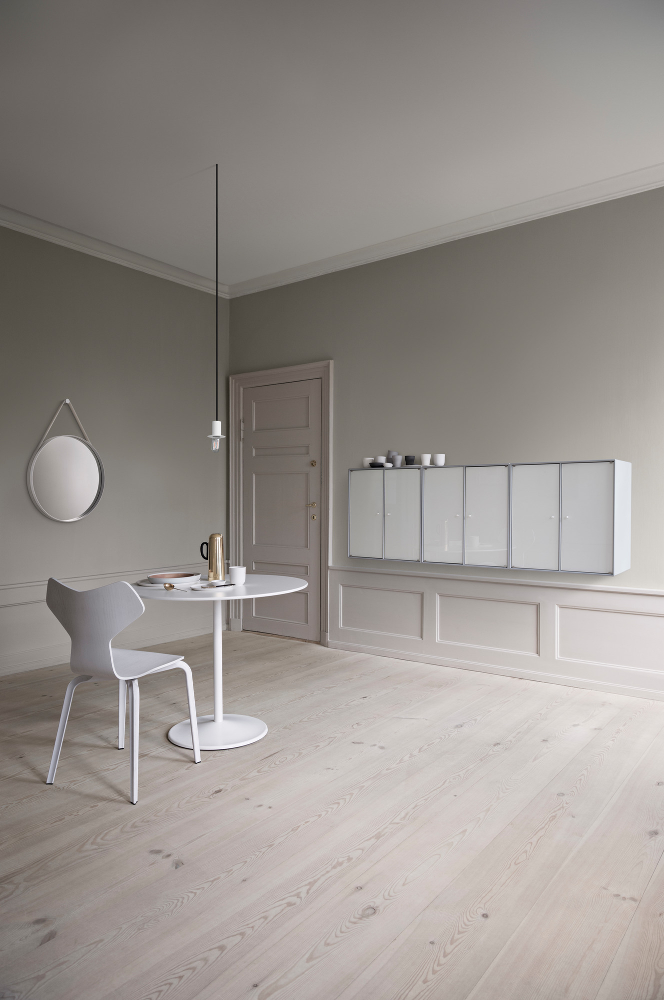 Heller Raum mit Panton Table Tisch, weißem Stuhl und Montana Wandregalen für modernes Wohnen.