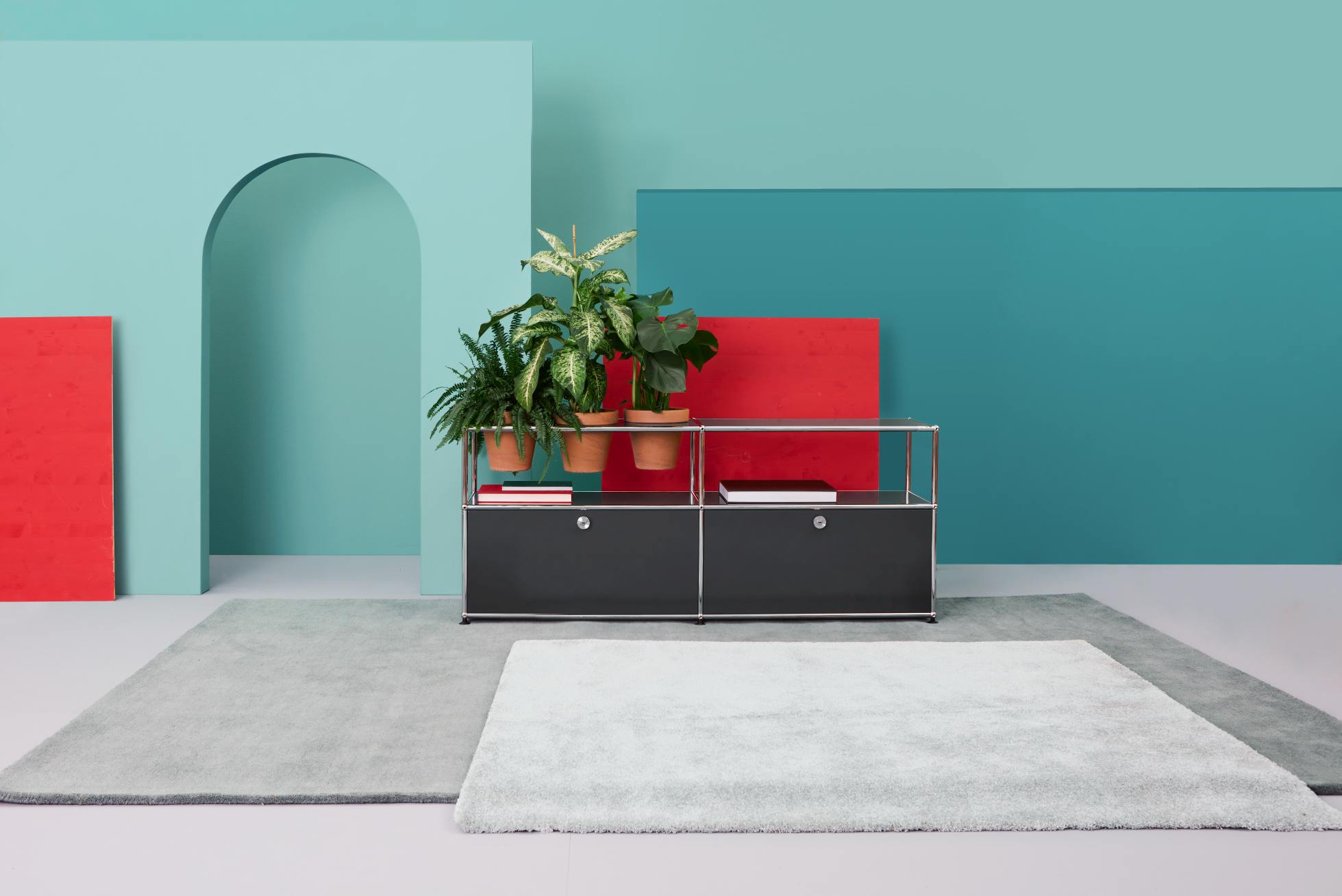 Pflanzenwelten Sideboard Konfiguration 1 USM Haller Braun mit Pflanzen und Dekoration vor farbigem Hintergrund.